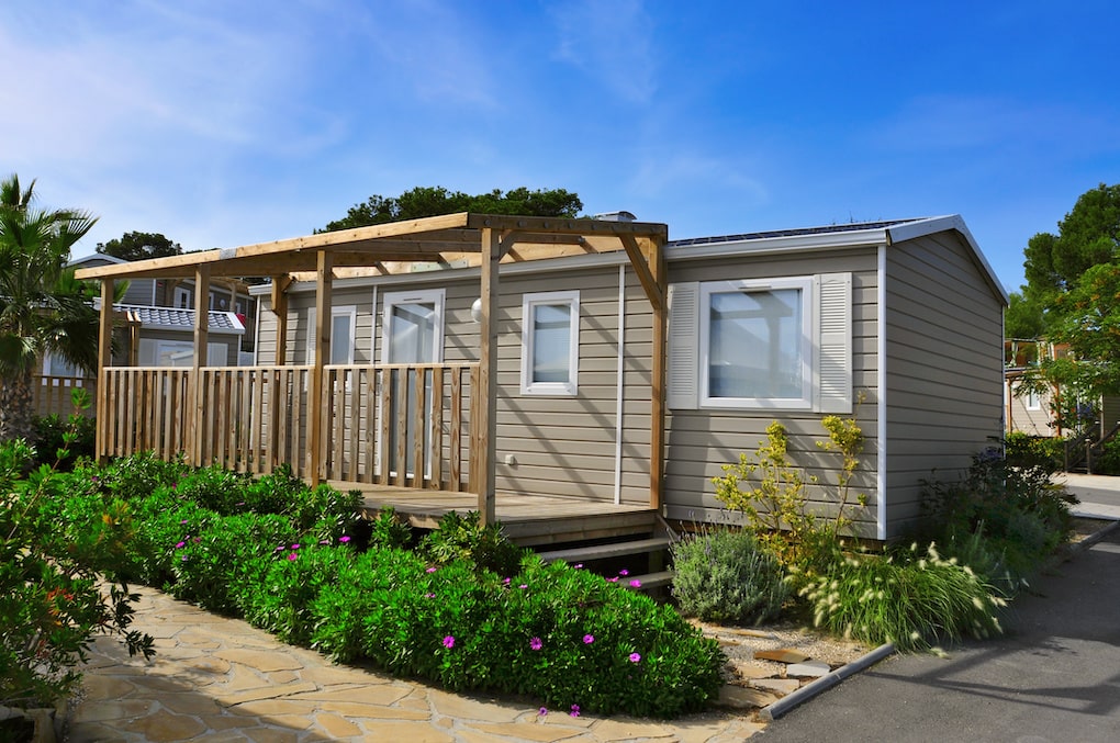 prefabricated antique home surrounded by bushes with flowers