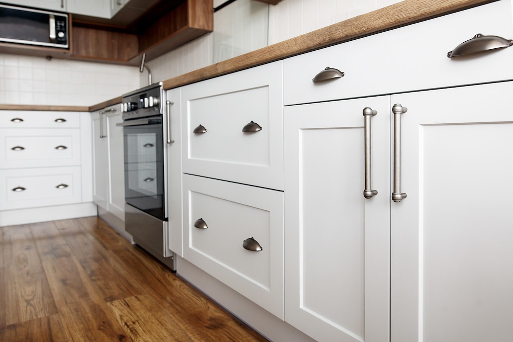 white cabinets with gray handles after replacing kitchen cabinets